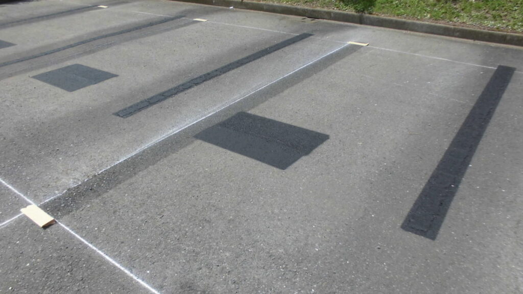 黒ペンキによる駐車場番号消し